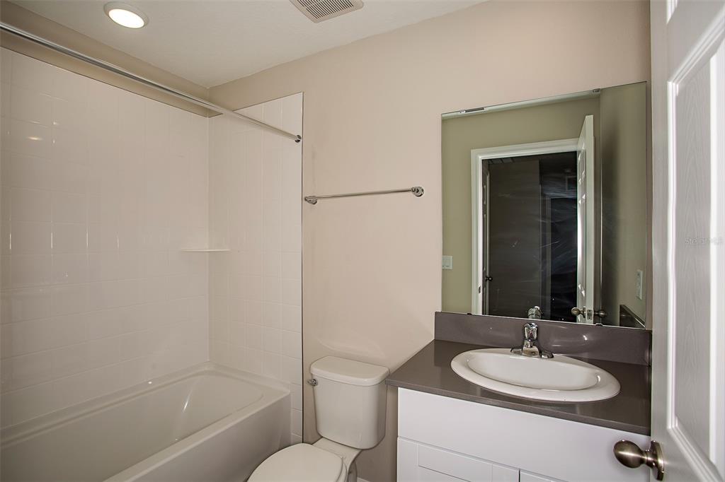 15232 Maude Lndg Loop Wimauma, FL 33598 - Photo 15 of 22 a bathroom with a granite countertop sink toilet and shower