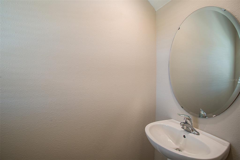 15232 Maude Lndg Loop Wimauma, FL 33598 - Photo 18 of 22 a bathroom with a sink and mirror