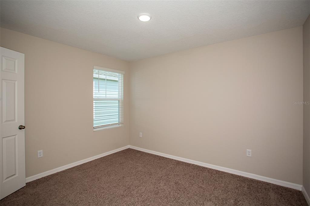 15232 Maude Lndg Loop Wimauma, FL 33598 - Photo 19 of 22 an empty room with a window