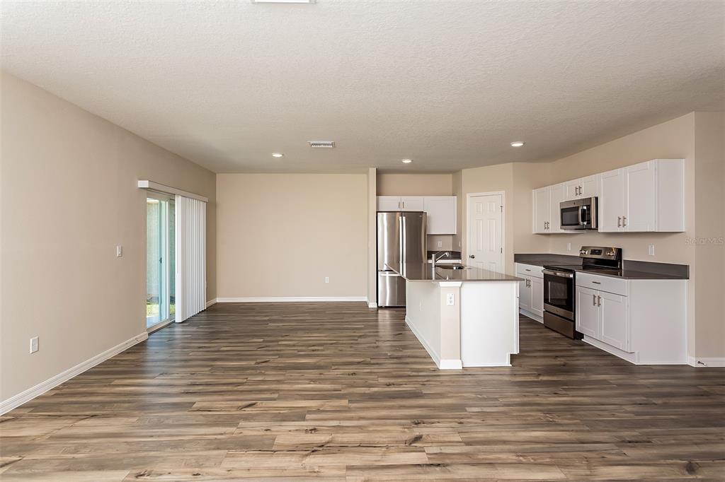 15232 Maude Lndg Loop Wimauma, FL 33598 - Photo 8 of 22 a kitchen with a refrigerator and a stove top oven