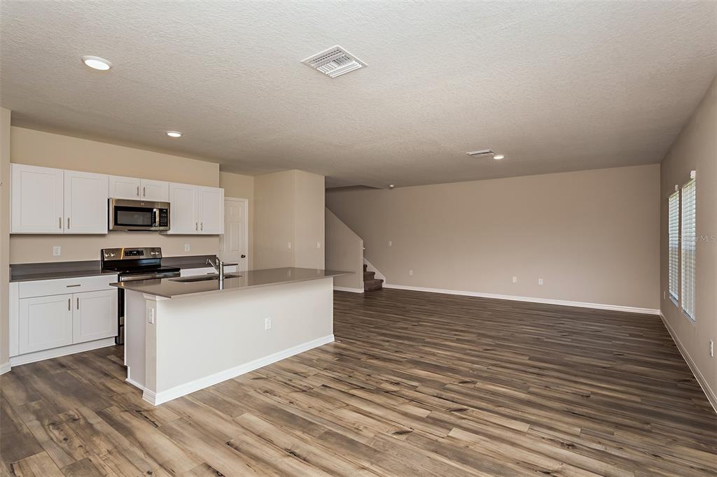 15232 Maude Lndg Loop Wimauma, FL 33598 - Photo 9 of 22 a kitchen with stainless steel appliances a stove top oven and a refrigerator