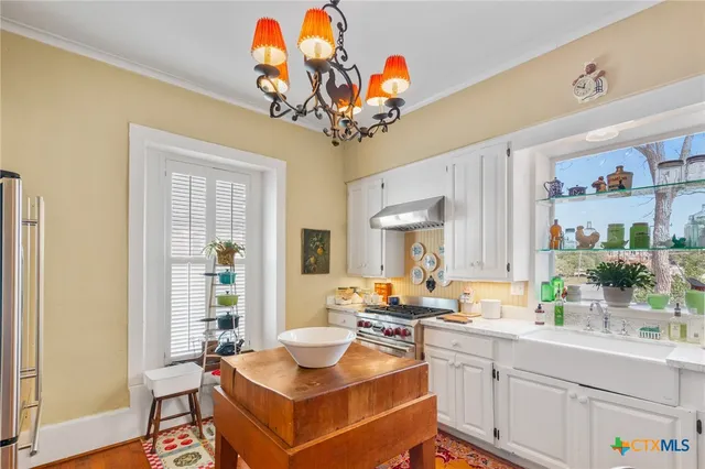 a very nice looking dining room with wooden floor and a chandelier