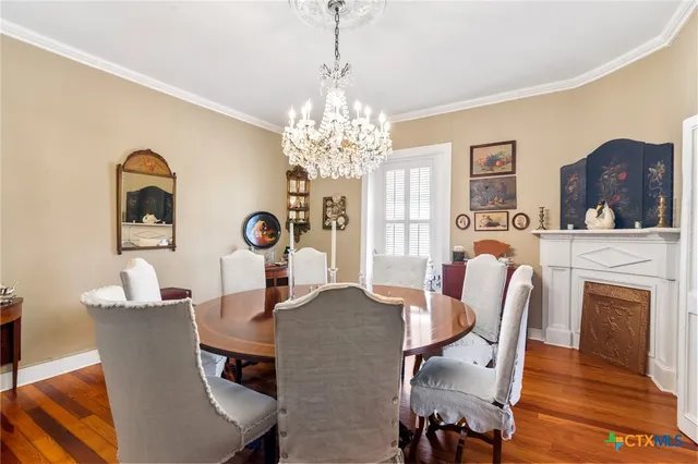 a view of a dining room with furniture a chandelier and wooden floor