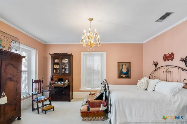 a bedroom with a bed and a chandelier