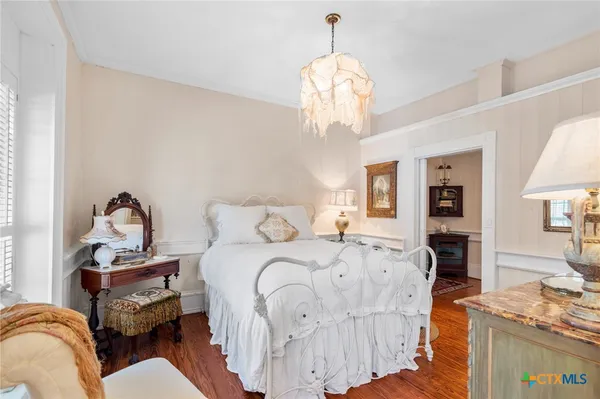 a bedroom with bed and a chandelier