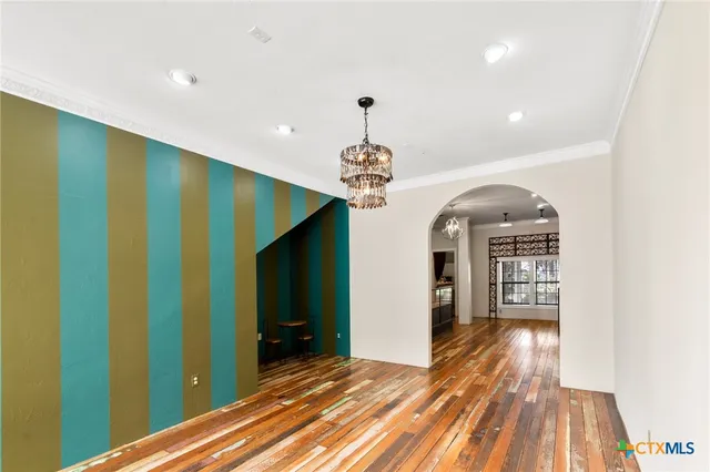 a view of a room with chandelier entryway and wooden floor