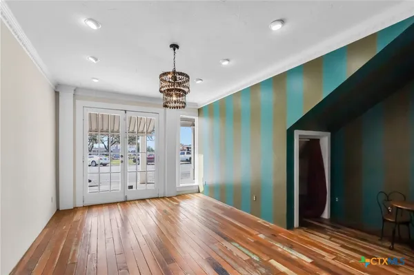a view of an empty room with wooden floor