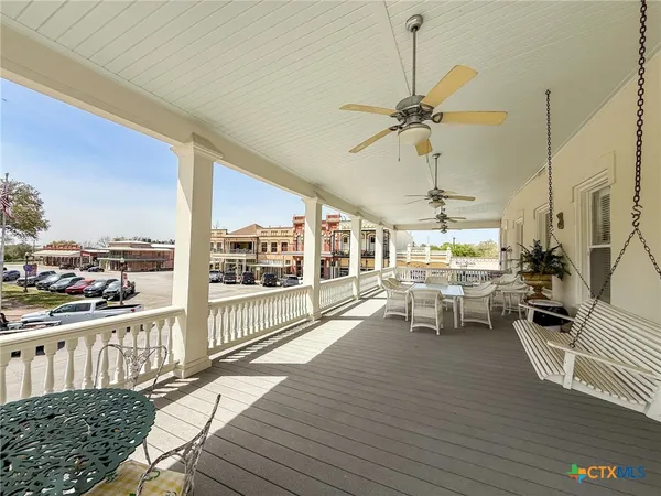 a view of a dining room and livingroom with furniture wooden floor a chandelier