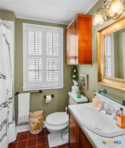 a bathroom with a sink a toilet and a window