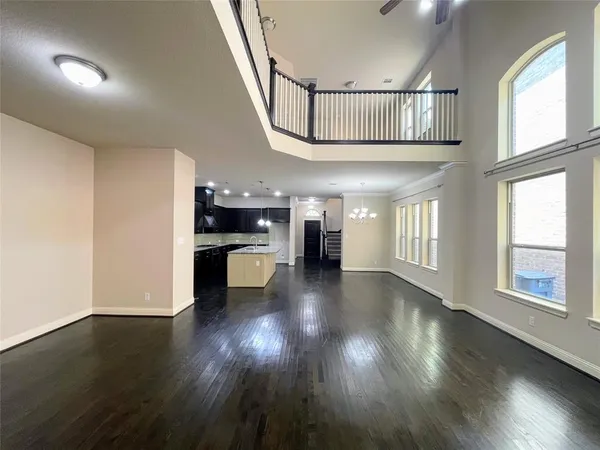 a view of a kitchen island a chandelier and wooden floor