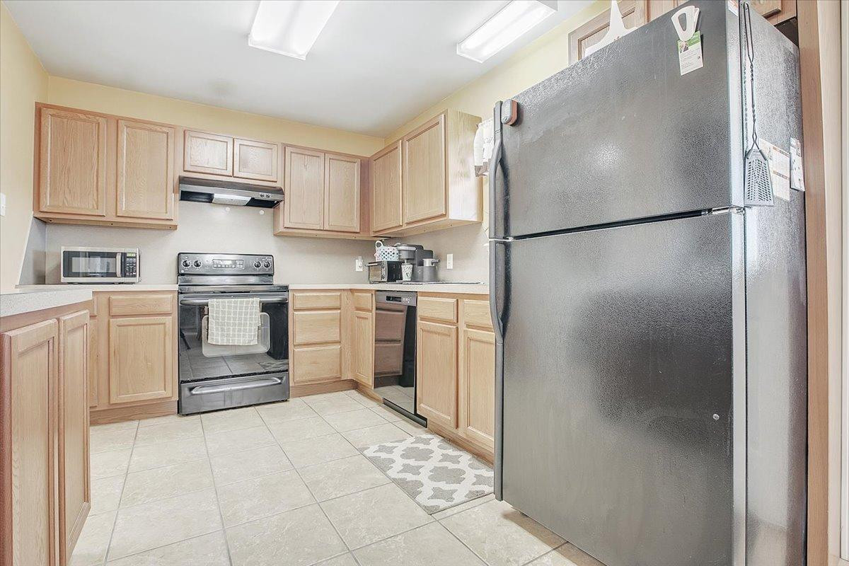 903 Xavier Street Lubbock, TX 79403 - Photo 15 of 28 a kitchen with stainless steel appliances granite countertop a refrigerator and a sink