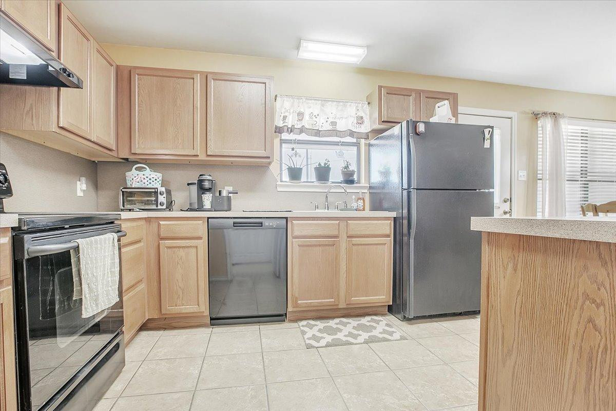 903 Xavier Street Lubbock, TX 79403 - Photo 18 of 28 a kitchen with a sink a refrigerator and cabinets