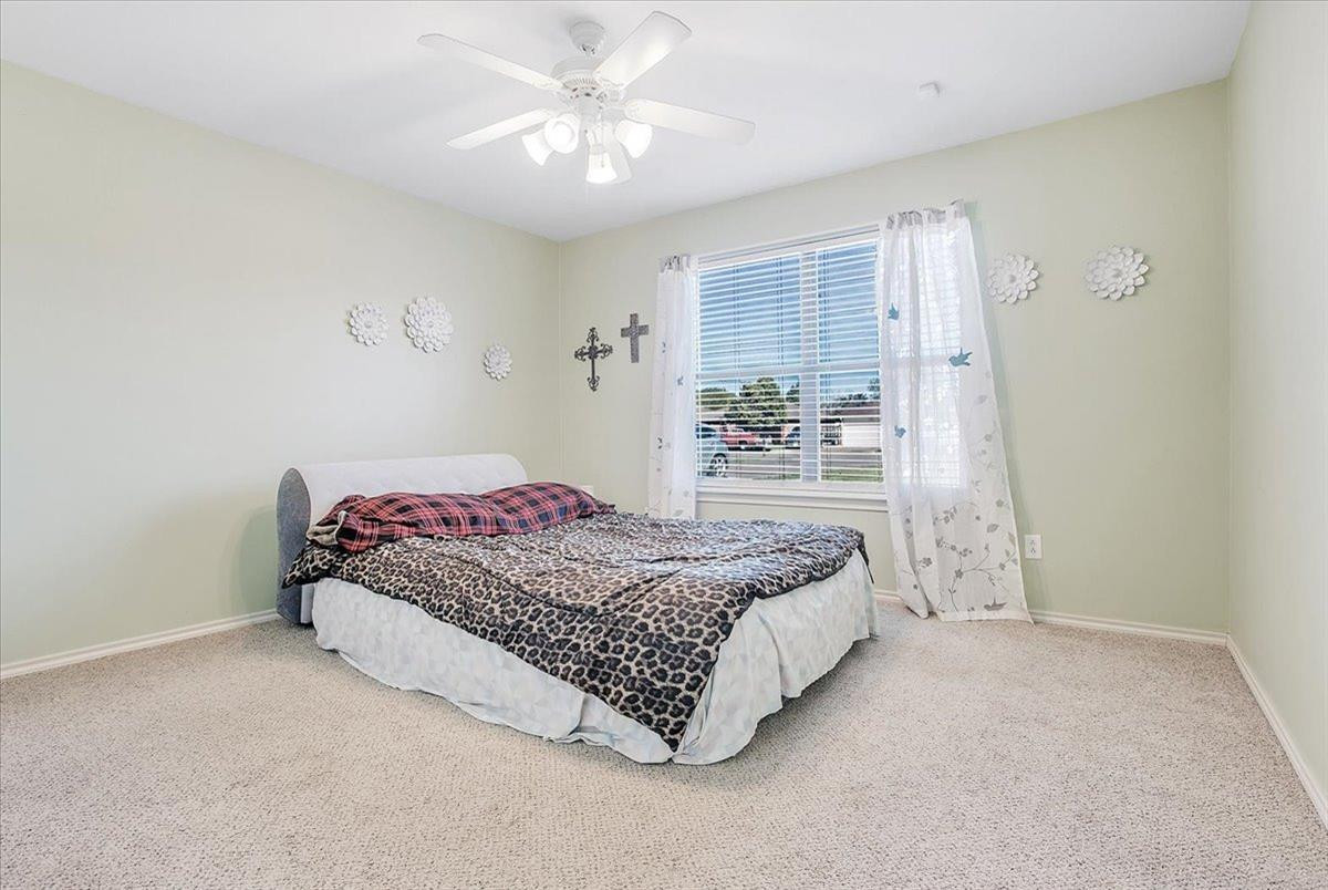 903 Xavier Street Lubbock, TX 79403 - Photo 3 of 28 a bedroom with a large bed and a chandelier
