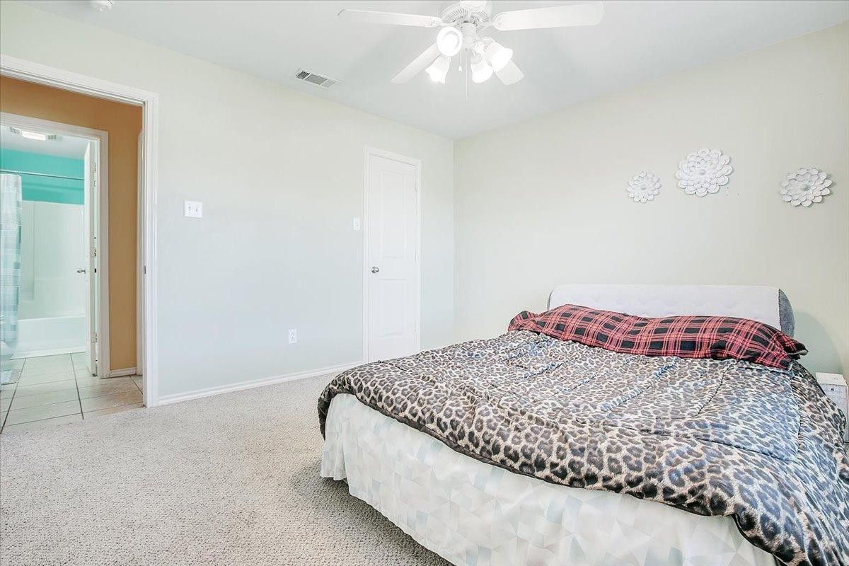 903 Xavier Street Lubbock, TX 79403 - Photo 4 of 28 a bedroom with a bed and a chandelier