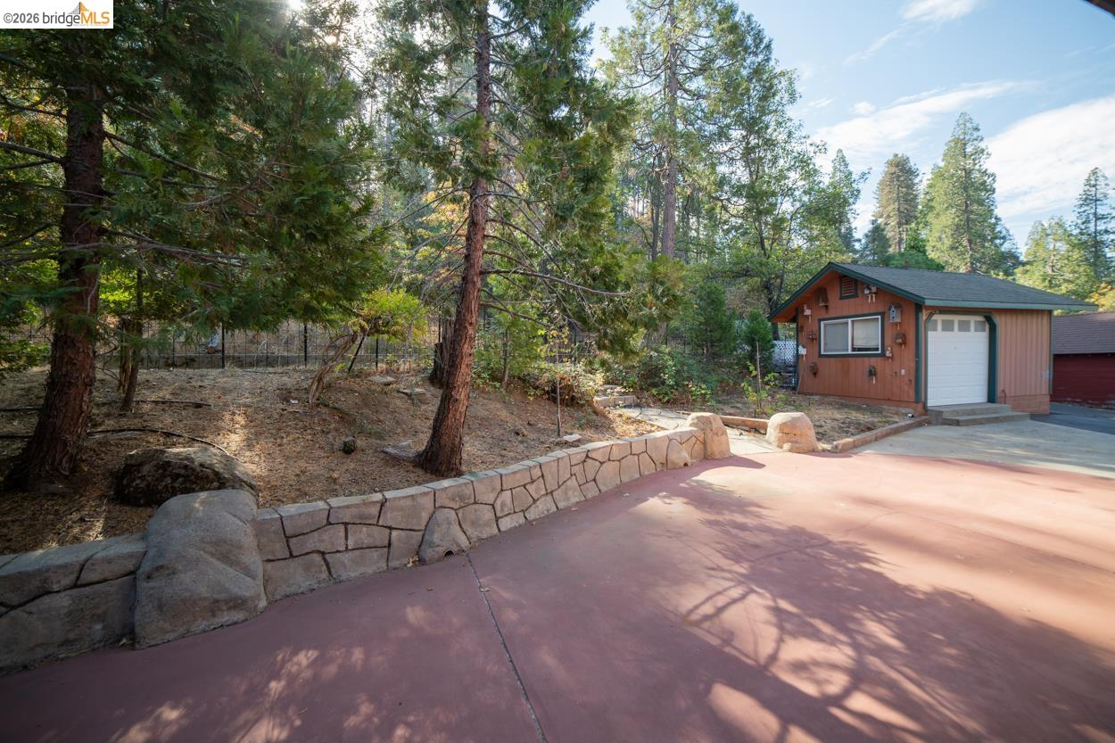 Red-toned driveway with a decorative stone retaining wall