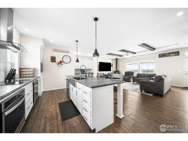 a kitchen with stainless steel appliances a refrigerator a stove top oven and white cabinets