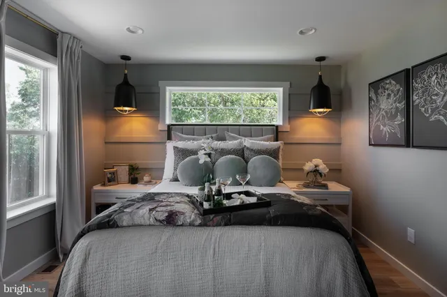 a bedroom with a bed and large windows