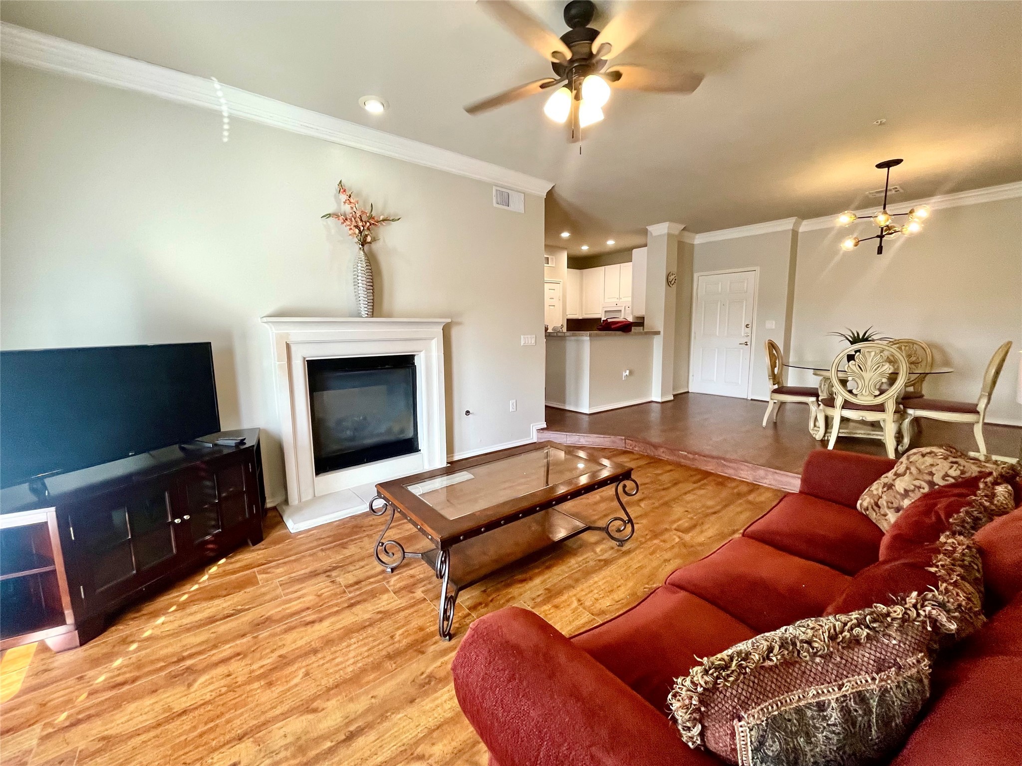 a living room with furniture a flat screen tv and kitchen view