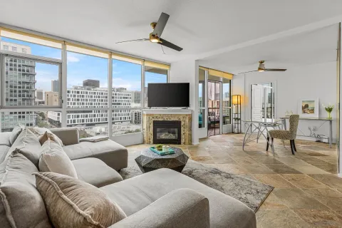 a living room with furniture a fireplace and a large window