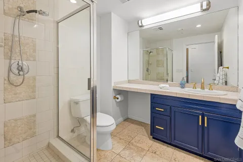a bathroom with a double vanity sink toilet and shower