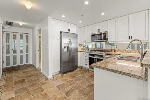 a kitchen with stainless steel appliances granite countertop a refrigerator sink and stove
