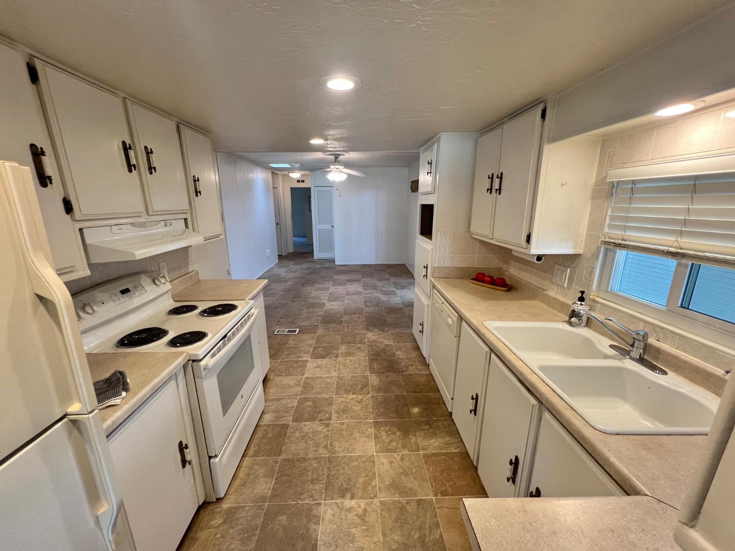 3955 Coffee Road, Unit 53 Modesto, CA 95355 - Photo 21 of 39 a kitchen with granite countertop a sink stove and refrigerator