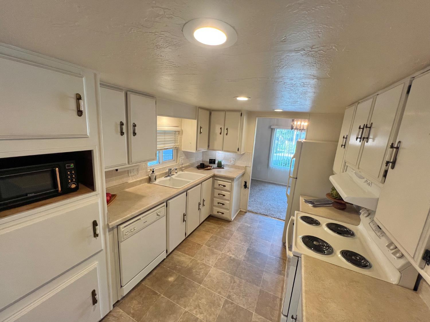 3955 Coffee Road, Unit 53 Modesto, CA 95355 - Photo 22 of 39 a kitchen with white cabinets and white appliances