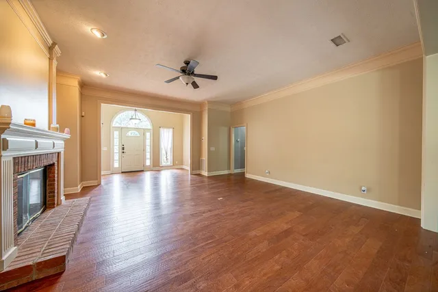 a view of an empty room with a fireplace and a window