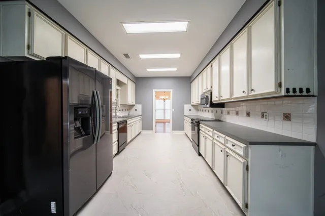 a kitchen with stainless steel appliances granite countertop a refrigerator and a stove