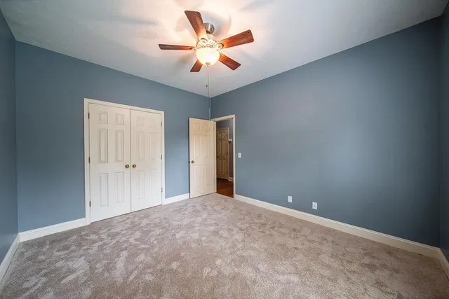 a view of a big room with closet and a ceiling fan