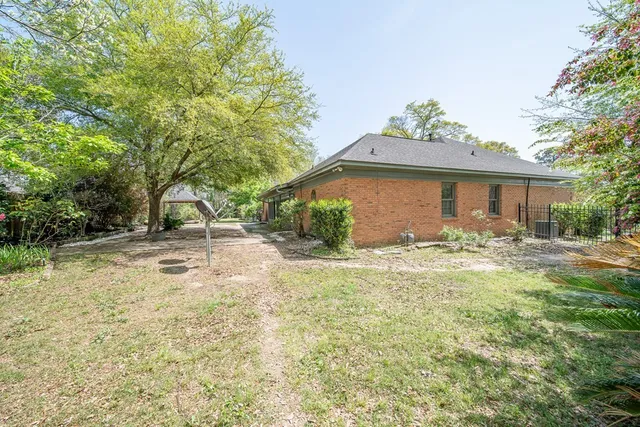 a view of a house with backyard and sitting area