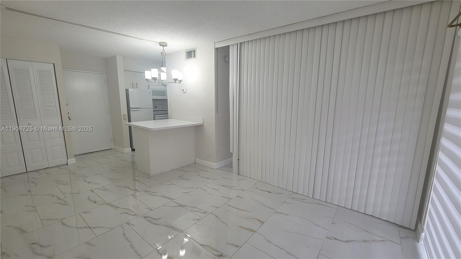 5201 Northwest 7th Street, Unit 106 Miami, FL 33126 - Photo 3 of 20 an empty room with kitchen view