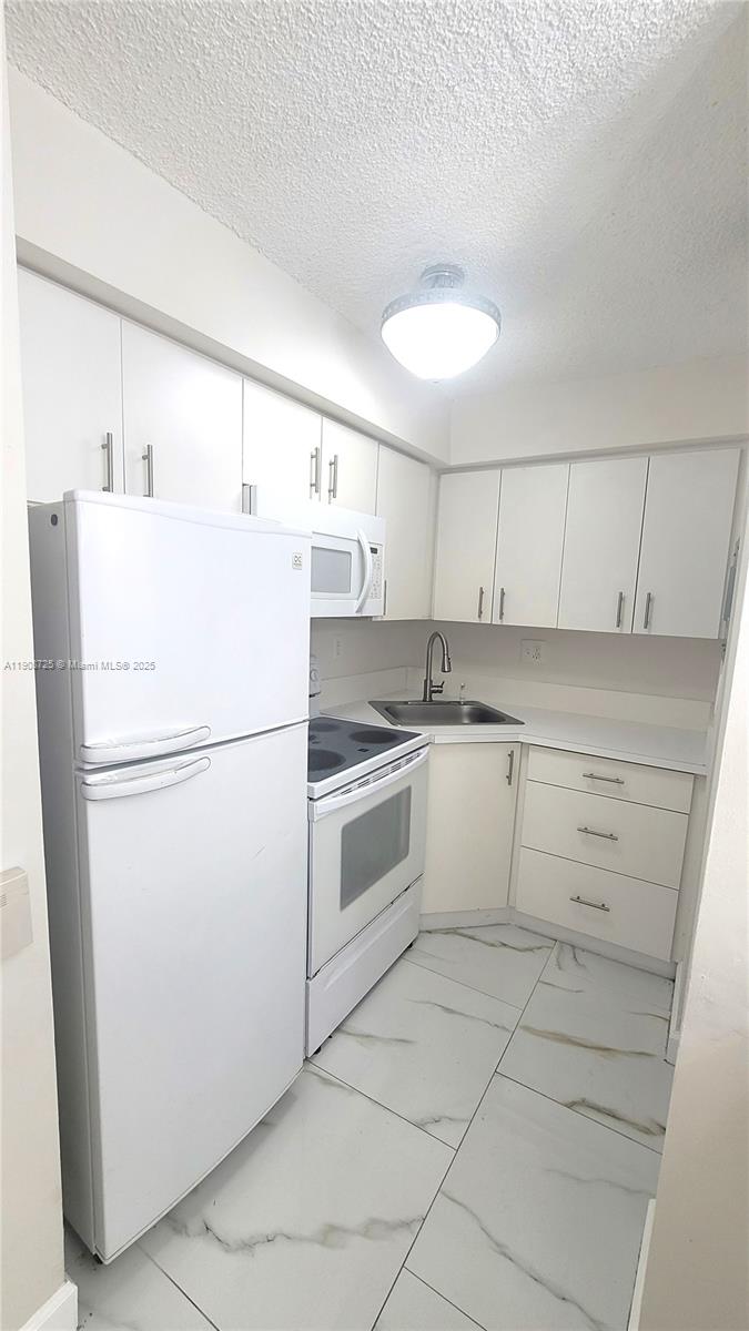 5201 Northwest 7th Street, Unit 106 Miami, FL 33126 - Photo 6 of 20 a white refrigerator freezer sitting inside of a kitchen