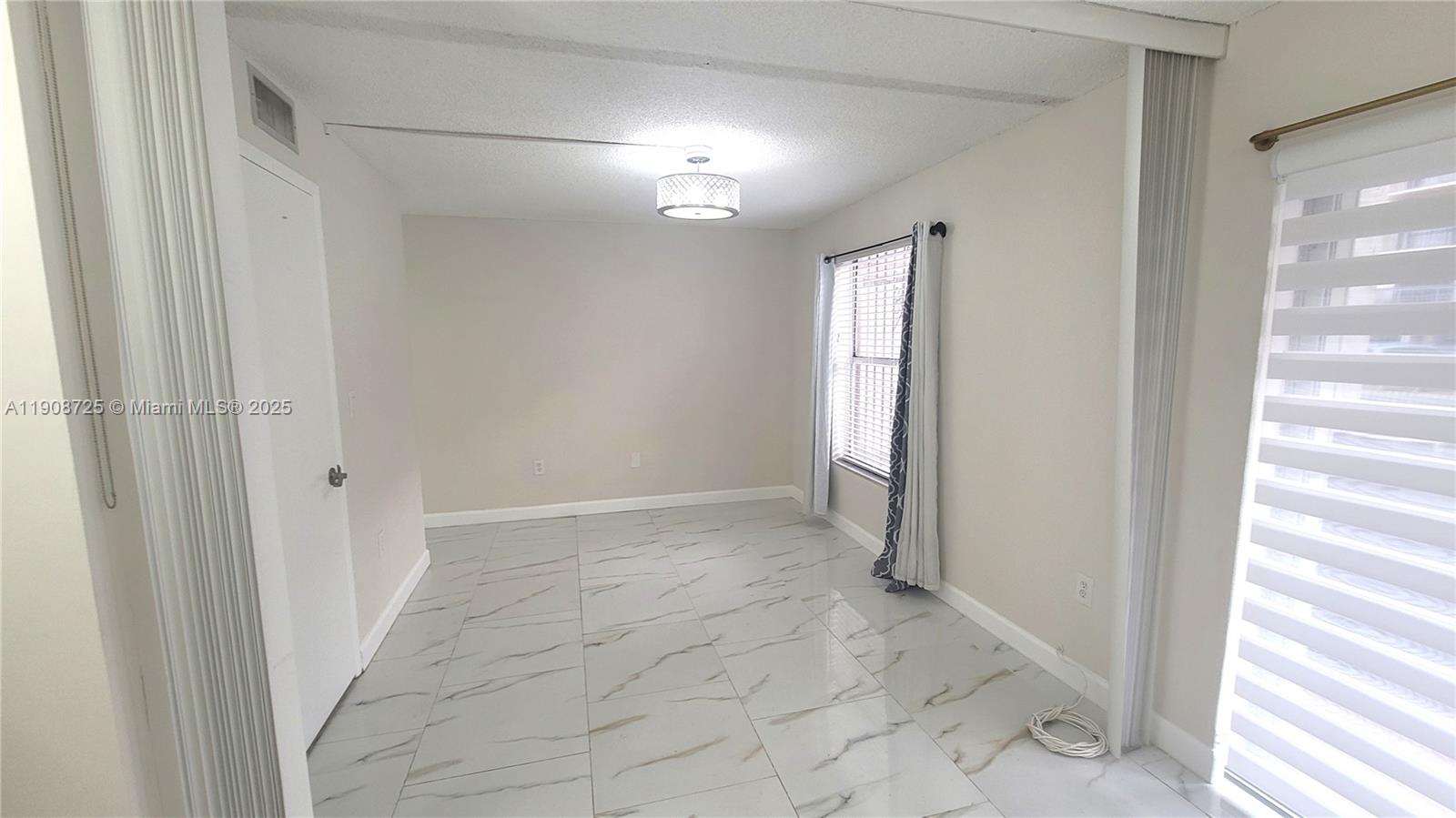5201 Northwest 7th Street, Unit 106 Miami, FL 33126 - Photo 8 of 20 a view of a hallway with windows and chandelier fan