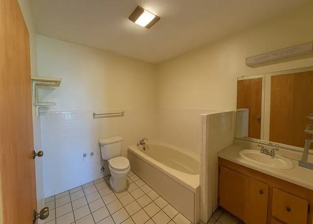 a bathroom with a granite countertop toilet a sink and a bathtub