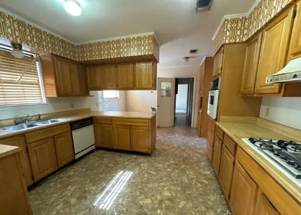 a kitchen with a stove a sink and a refrigerator