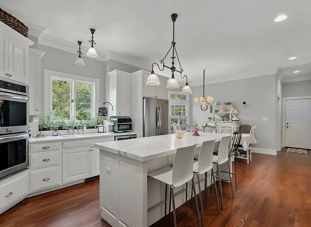 2 Country Way Hopkinton, MA 01748 - Photo 11 of 38 a large kitchen with granite countertop a island a stove a sink a dining table and chairs with wooden floor