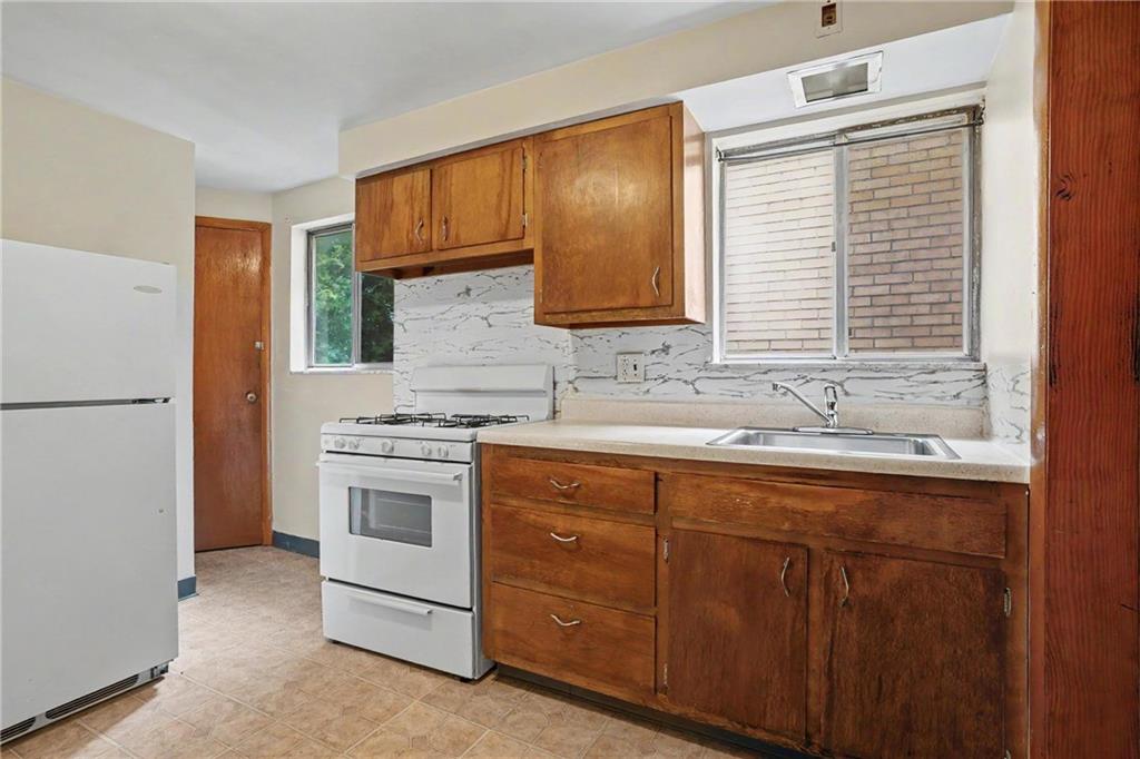 218 Vine Street Homestead, PA 15120 - Photo 11 of 36 a kitchen with stainless steel appliances granite countertop a sink stove and refrigerator