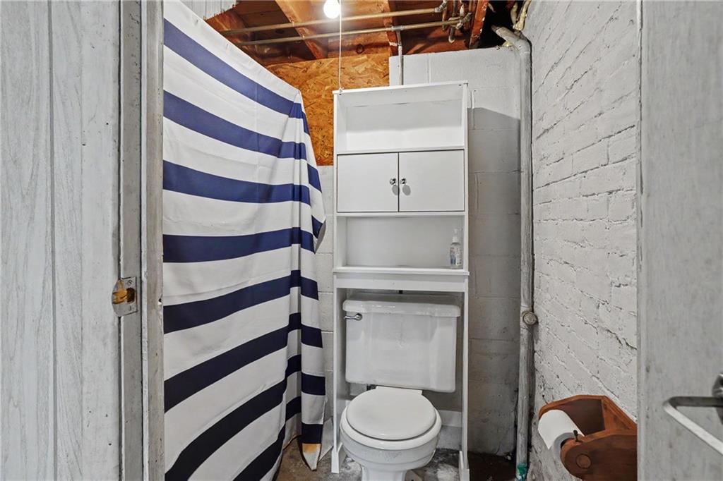 218 Vine Street Homestead, PA 15120 - Photo 19 of 36 a white toilet sitting next to a shower curtain