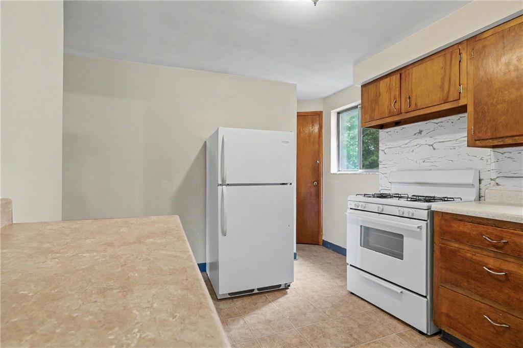 218 Vine Street Homestead, PA 15120 - Photo 10 of 36 a kitchen with a refrigerator sink stove and cabinets
