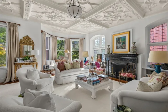 a living room with furniture fireplace and a large window