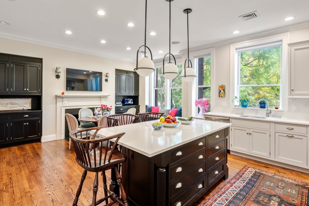 314 Dartmouth Street, Unit B Boston, MA 02116 - Photo 11 of 34 a kitchen with kitchen island granite countertop a sink and a refrigerator