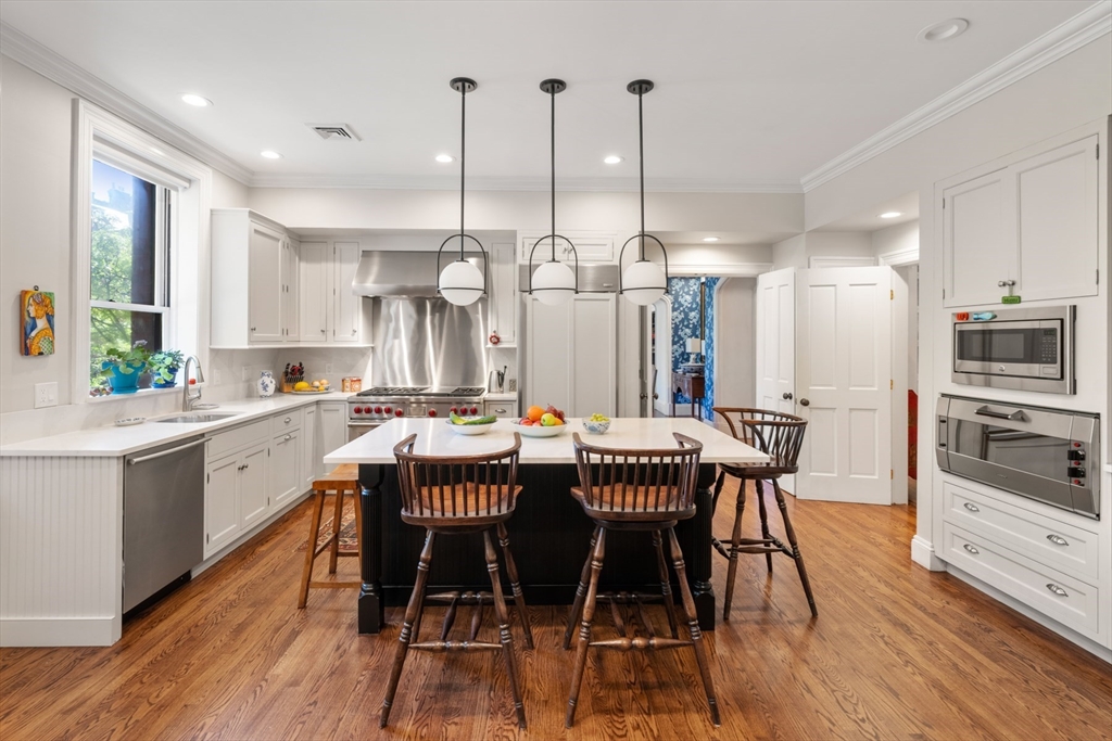 314 Dartmouth Street, Unit B Boston, MA 02116 - Photo 12 of 34 a kitchen with stainless steel appliances kitchen island granite countertop a table chairs sink and cabinets