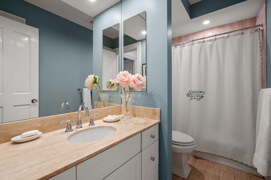 314 Dartmouth Street, Unit B Boston, MA 02116 - Photo 27 of 34 a bathroom with a granite countertop sink a toilet and shower curtain