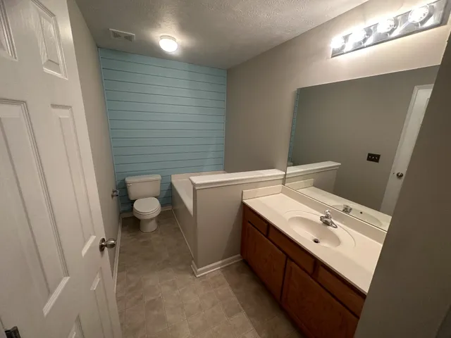 a bathroom with a sink toilet and mirror