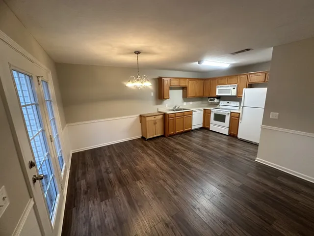 a large kitchen with a wooden floor and cabinets