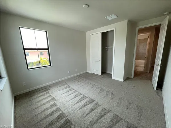 an empty room with windows and closet