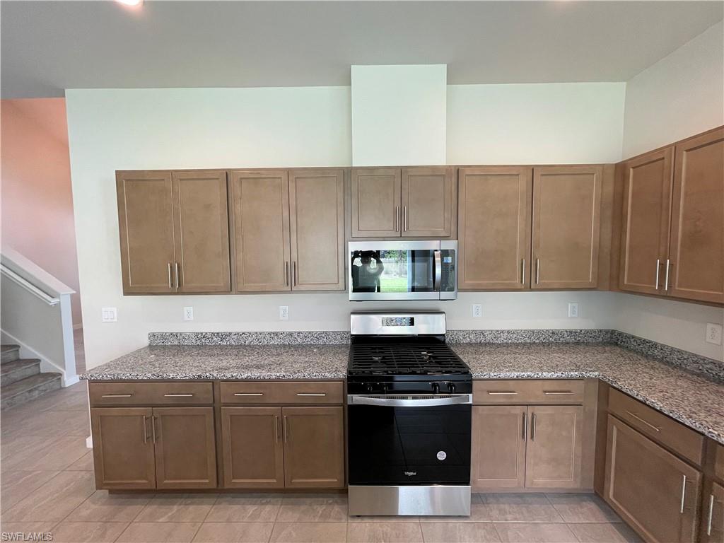 14815 Loggerhead Drive Naples, FL 34120 - Photo 5 of 29 a kitchen with stainless steel appliances granite countertop a stove a sink and a white cabinets