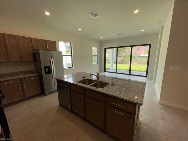 a kitchen with stainless steel appliances granite countertop a sink and a refrigerator