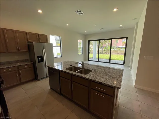 a kitchen with stainless steel appliances granite countertop a sink and a refrigerator